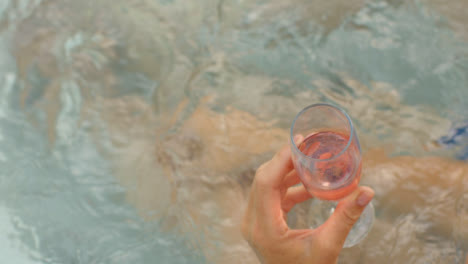 Hochwinkelaufnahme-Mit-Blick-Auf-Die-Hand,-Die-Champagnerglas-Im-Whirlpool-Hält