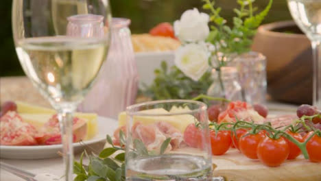 Pull-Focus-Shot-from-an-Alfresco-Dinner-Table-Spread-to-Glass-of-White-Wine