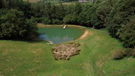 Drone-Shot-Orbiting-Scenic-Lake-On-Edge-of-Woodland