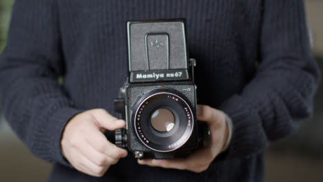 Close-Up-Shot-of-Persons-Hands-Holding-Mamiya-RB67-and-Taking-Photo