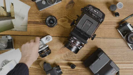 Top-Down-Shot-of-Photographers-Hands-Flicking-Through-Photos-Before-Picking-Up-Camera