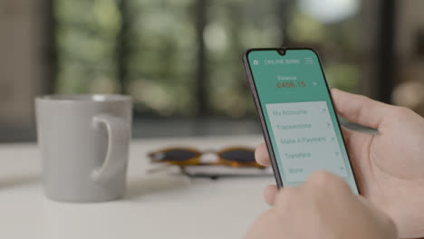 Sliding-Shot-Approaching-a-Hand-Holding-a-Smartphone-On-Mobile-Banking-App