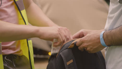 Close-Up-Shot-of-Festival-Security-Guard-Finding-Drugs-In-Rucksack-During-Bag-Check