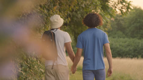 Pull-Focus-Shot-of-Same-Sex-Couple-Walking-Along-Country-Path