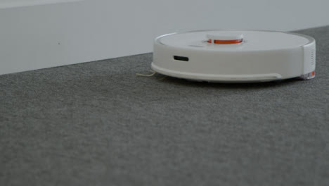 Close-Up-Shot-of-Robotic-Vacuum-Cleaner-Cleaning-Carpet