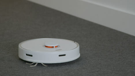 Close-Up-Shot-of-Robotic-Vacuum-Cleaner-Cleaning-a-Carpet