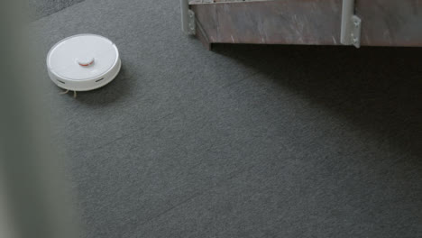 High-Angle-Shot-of-a-Automatic-Robotic-Vacuum-Cleaner-Cleaning-Carpet