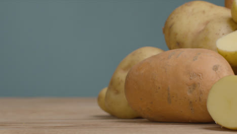 Sliding-Shot-of-Assorted-Potatoes-On-a-Rustic-Wooden-Table