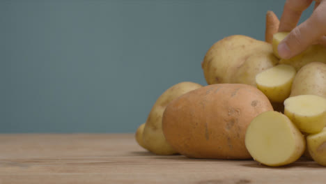 Sliding-Shot-Revealing-Pile-of-Potatoes-as-Hand-Takes-One-Away-01