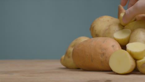 Close-Up-Shot-of-Pile-of-Assorted-Potatoes-as-Hand-Takes-One-Away