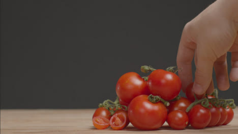 Mittlerer-Schuss-Tomatenhaufen-Als-Hand-Nimmt-Einen-Weg