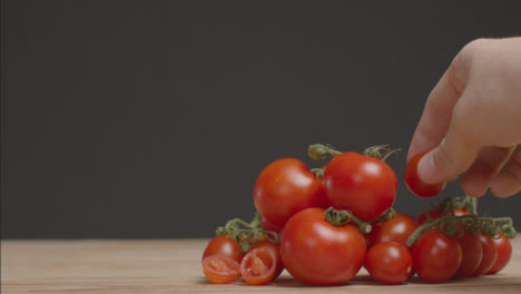 Mittlerer-Schuss-Tomatenhaufen-Als-Hand,-Die-Einen-Auf-Den-Stapel-Legt