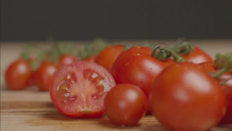 Nahaufnahme-Einer-Hand,-Die-Eine-Halbe-Tomate-Neben-Die-Tomatenrebe-Legt