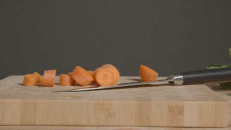 Tracking-Shot-from-Knife-On-Chopping-Board-to-Pile-of-Vegetables