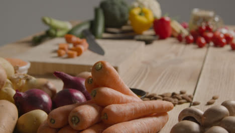 Pull-Focus-Shot-of-Pile-of-Vegetables-On-a-Rustic-Wooden-Table