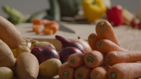 Pull-Focus-Shot-of-Pile-of-Vegetables-On-a-Rustic-Wood-Table