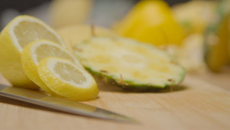 Ziehen-Sie-Den-Fokusschuss-Vom-Küchenmesser-Auf-Geschnittene-Zitrone-Und-Ananas