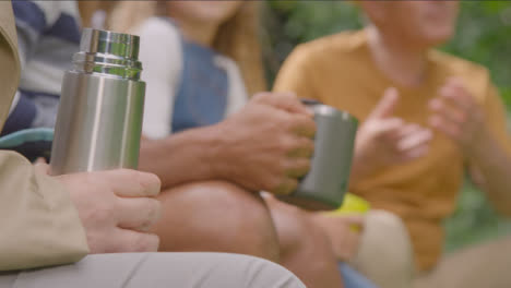 Pull-Focus-Shot-of-People-Holding-Drinks-On-Camping-Trip-02