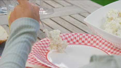 Over-the-Shoulder-Shot-of-Young-Girl-Serving-Herself-Coleslaw-