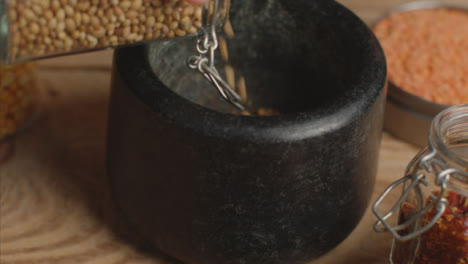 Tracking-In-Shot-Pouring-Spices-into-Mortar-and-Pestle-on-Table
