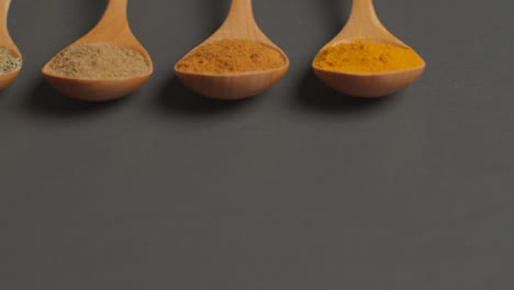 Sliding-Shot-of-Herbs-and-Spices-in-Wooden-Spoons