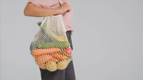 Seguimiento-De-Disparo-De-Mujer-Adulta-Joven-Sosteniendo-Una-Bolsa-De-Verduras-01