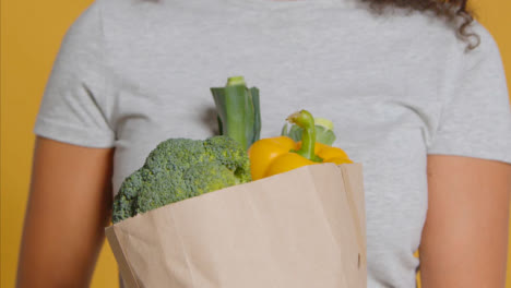 Close-Up-Shot-of-Young-Adult-Woman-with-Brown-Paper-Bag-of-Vegetables