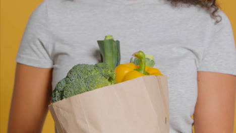 Primer-Plano-De-Una-Mujer-Adulta-Joven-Con-Una-Bolsa-De-Papel-Marrón-De-Verduras