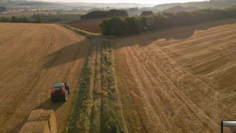 Drone-Shot-Rising-Above-Tractor-Working-In-Rural-Fields