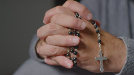 Close-Up-Shot-of-Senior-Mans-Hands-Holding-Rosary-Beads