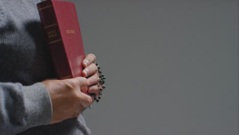 Side-Profile-Shot-of-Senior-Man-Holding-Holy-Bible-with-Copy-Space