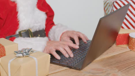 Hochwinkelaufnahme-Des-Weihnachtsmanns,-Der-Auf-Dem-Laptop-Tippt