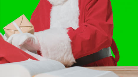 Close-Up-Shot-of-Santa-Placing-Gifts-In-a-Big-Red-Sack