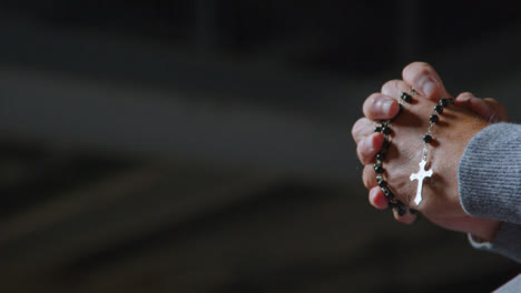 Low-Angle-Shot-of-a-Senior-Mans-Hands-Holding-Some-Rosary-Beads