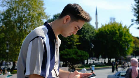 Mittlere-Aufnahme-Eines-Jungen-Mannes,-Der-Vor-Dem-Brunnen-Auf-Dem-Sultanahmet-Platz-Sitzt