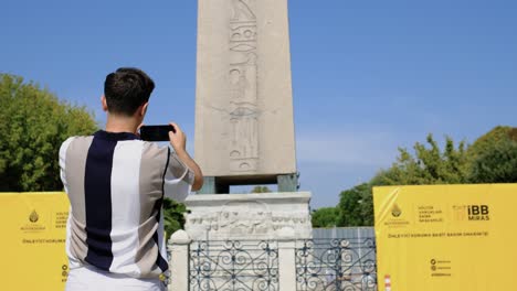 Disparo-De-ángulo-Bajo-Del-Joven-Fotografiando-El-Obelisco-De-Estambul