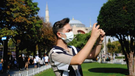 Close-Up-Shot-of-Young-Man-Taking-Photos-with-Mobile-Phone-Outside-Hagia-Sophia