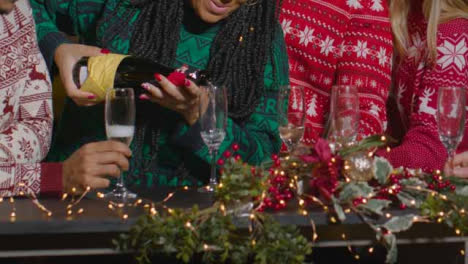 Sliding-Shot-of-Friends-Pouring-Champagne-During-Christmas-Celebrations