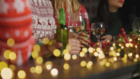Captura-De-Seguimiento-De-Amigos-Sentados-En-El-Bar-Con-Bebidas-Durante-Las-Celebraciones-Navideñas
