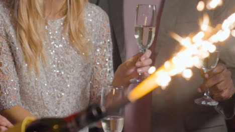 Close-Up-of-Sparklers-and-Friends-Celebrating-New-Years-with-Champagne