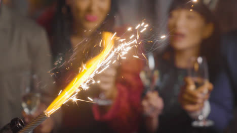 Close-Up-of-Sparklers-with-Friends-Celebrating-with-Champagne
