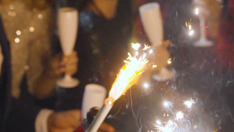 Close-Up-of-Friends-Celebrating-New-Years-Eve-with-Champagne-Sparklers
