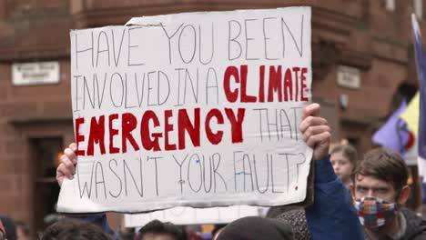 Handheld-Shot-of-Sign-Being-Held-Up-During-Climate-Change-Protests-In-Glasgow