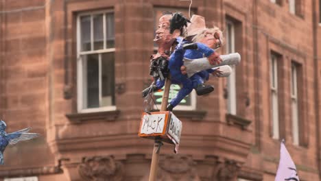 Handheld-Shot-of-Crude-Billionaire-Caricature-Piece-Being-Held-Up-During-Glasgow-Climate-Protests