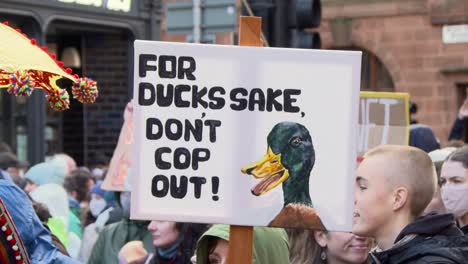 Handheld-Shot-of-a-Funny-Duck-Sign-During-Climate-Change-Protests-In-Glasgow