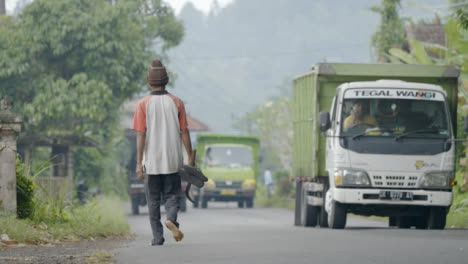 Plano-General-De-Hombre-Caminando-Y-Conduciendo-Vehículos-En-Bali.