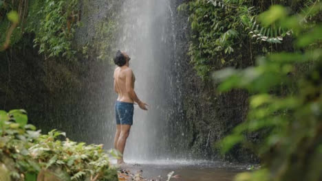 Mid-Shot-of-Man-Stood-Under-Waterfall-in-Bali