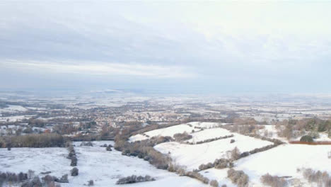 Drone-Shot-Flying-Over-Snow-Covered-Fields-and-Trees-Toward-Cotswold-Village-Part-2-of-2