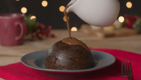 Nahaufnahme-Von-Schokolade,-Die-Auf-Christmas-Pudding-Gießt