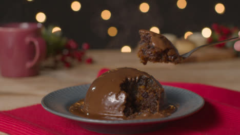 Close-Up-Shot-of-Fork-Picking-Piece-of-Chocolate-Covered-Christmas-Pudding